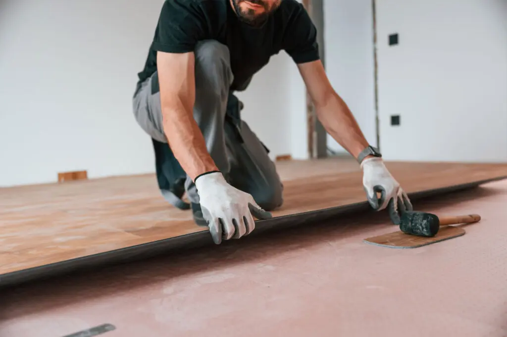 hand work man is installing new laminated wooden flooring