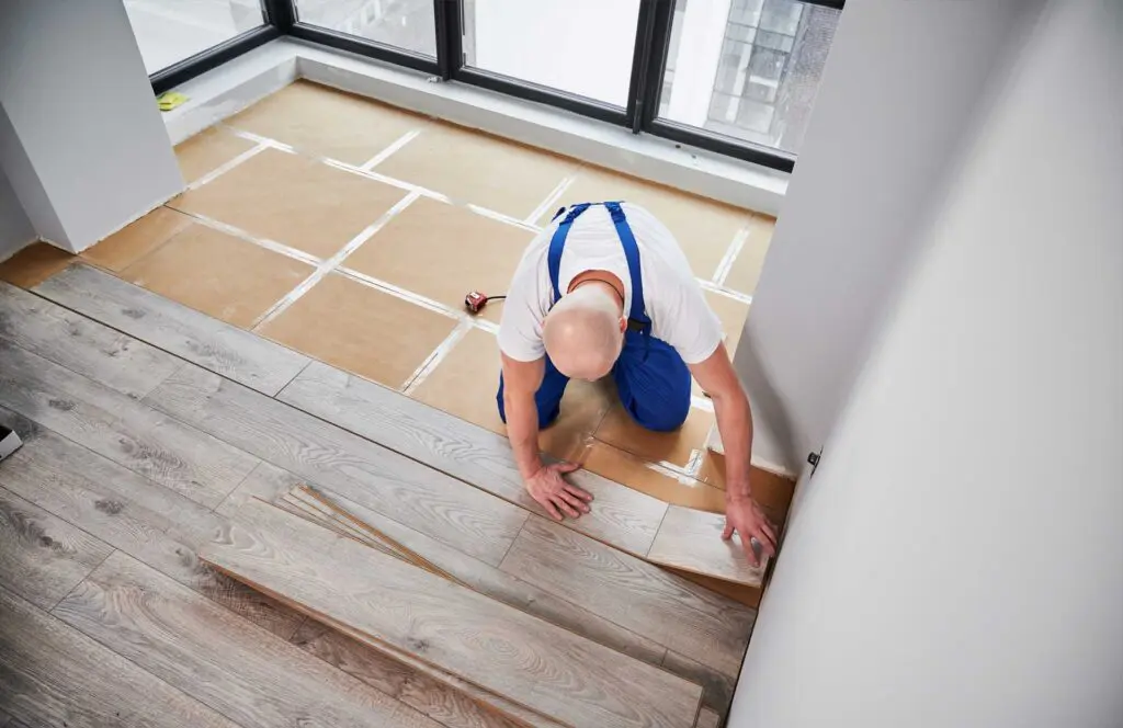 man laying laminate flooring in apartment under re 2023 11 27 04 50 47 utc